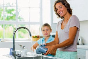 Mother and daughter washing dishes